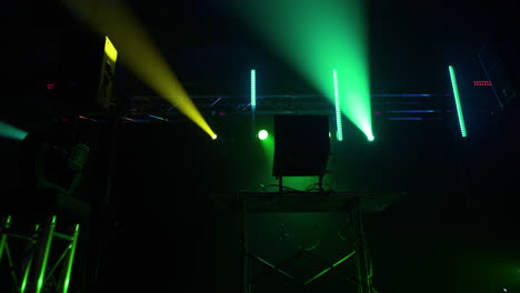 dolly shot of a dj stand in an empty warehouse with flashing strobe lights