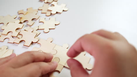 arranging the pieces of a jigsaw puzzle one-by-one on a table