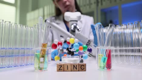 scientist conducting a chemistry experiment in a lab with zinc displayed