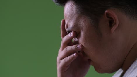 young handsome overweight asian man against green background