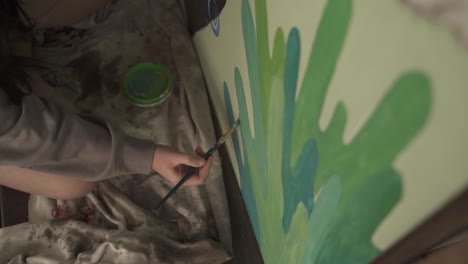 primer plano del artista pintando una pintura mural con un pincel