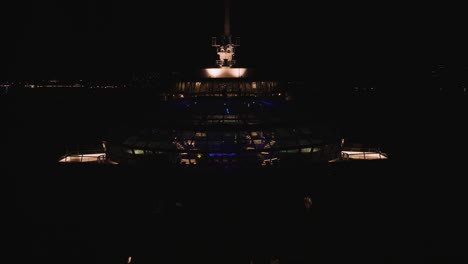 aerial drone shot over a pool and gym inside a large quantum of the seas cruise ship off the lahaina shores, hawaii, usa at dark night