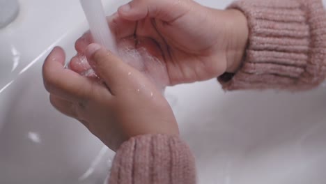 a child washing their hands in a sink