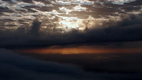 a view of the sun through the clouds from a plane window at sunset or sunrise time