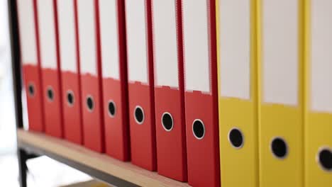 organizing and storing colorful binders on a shelf