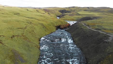 fast flowing white water skoga river in green valley in iceland