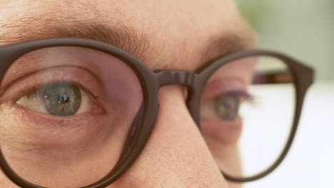 extreme close up shot of a man wearing eyeglasses and looking at something