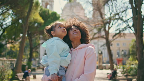 mother daughter watching park beauty standing at alley close up. happy family