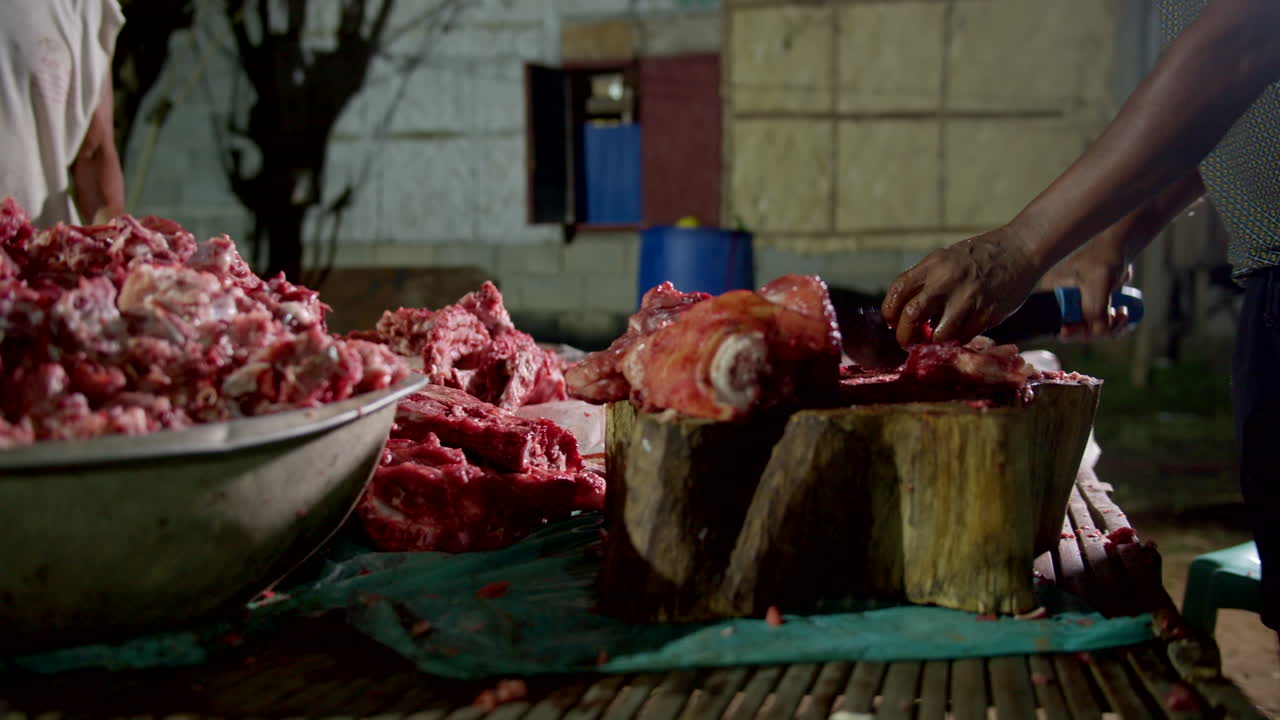 Butcher Cutting Meat at Night in a Rural Setting