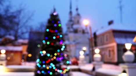 new year boke lights xmas christmas tree decoration and orthodox church in background. festive illumination, natural defocused blue bokeh background effect