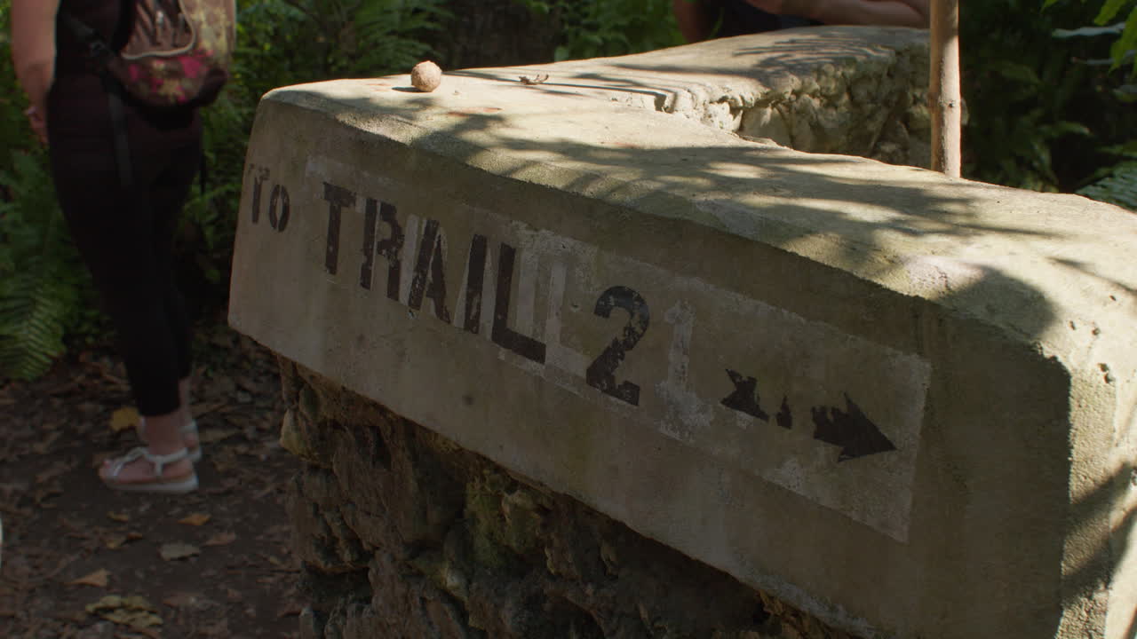 Graffiti paint on the concrete stone with direction for hiking trail in natural reserve, Zanzibar, Tanzania.