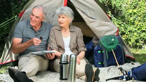 seniors looking at a map sitting near a tent