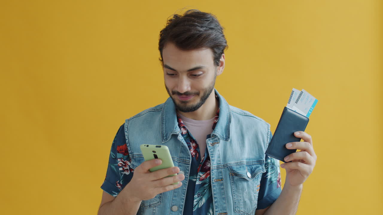 Man checking in at airport with tickets and phone.