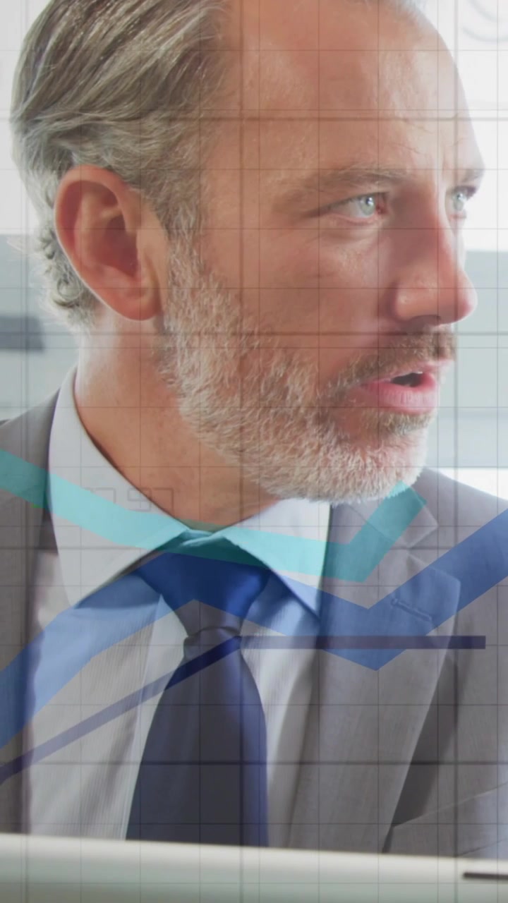 Vertical video: Man looking at laptop and speaking, charts overlaying and showing finance data