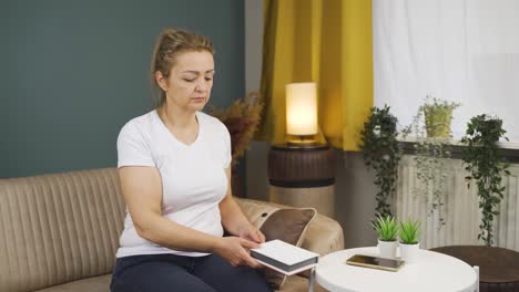 woman looking at family album with trembling hand.