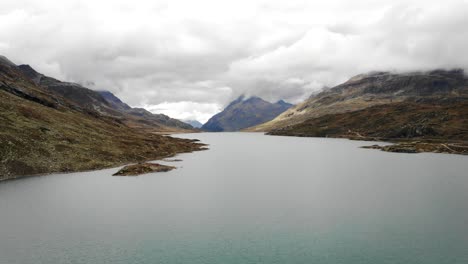sobrevuelo aéreo sobre el lago blanco en engadina, suiza en un día nublado en los alpes suizos, un área atravesada por el bernina express
