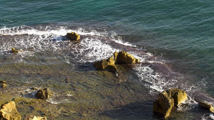 Costa rocciosa con onde subtropicali che si infrangono su una barriera corallina sommersa, Spagna