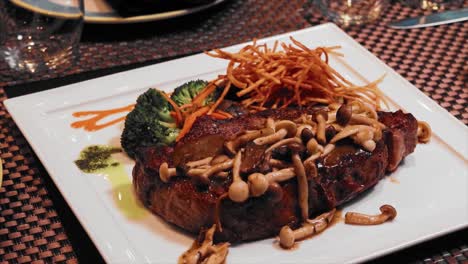 angus steak with mushroom sauce on a white plate