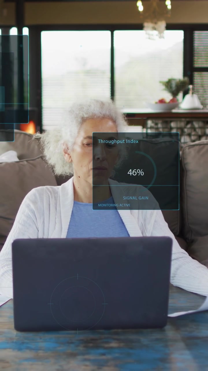 Vertikal video: Ældre kvinde holder papir og taster på en bærbar computer, hvilket skaber HUD-overlejringer, der viser tekniske målinger.