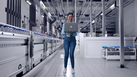 full body of asian female with her laptop with water production in bottling factory, solar power plant and wind turbine farm, working continuously