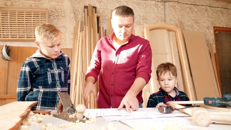 father and sons learning woodworking in a workshop