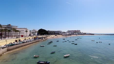 wide open view over boats in ocean in cadiz at low tide with beach