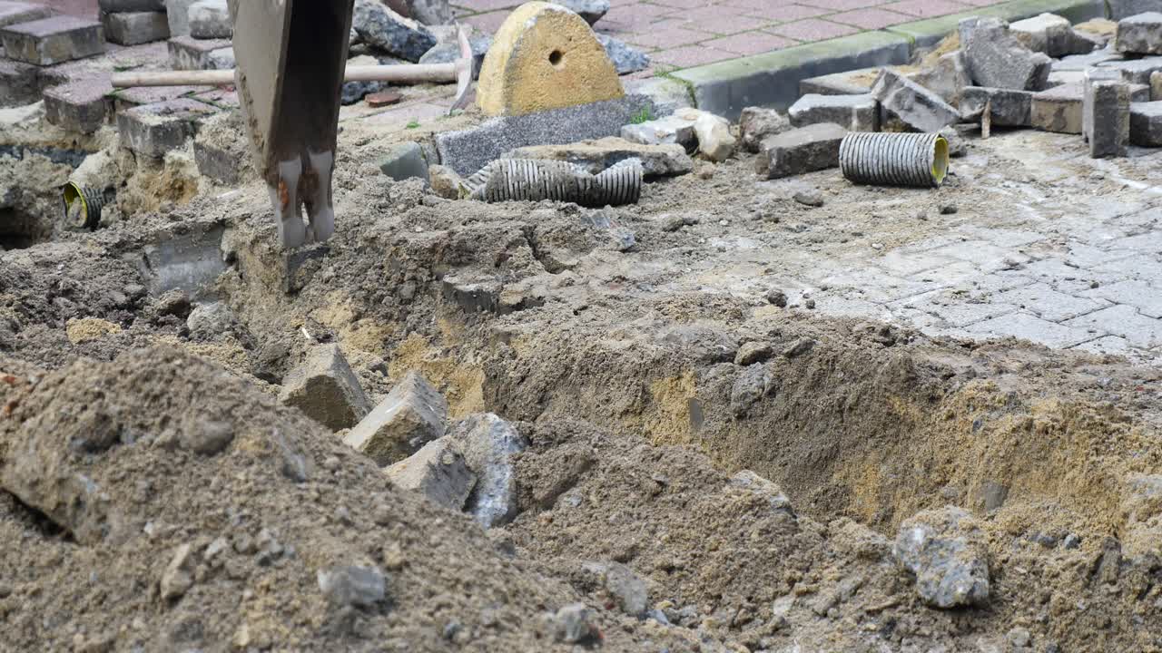 Un secchio di escavatore che scava nel suolo in un cantiere