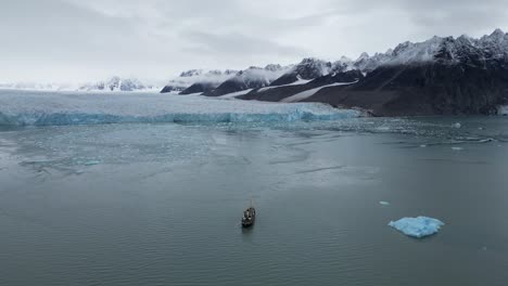 Barco-De-Expedición-Navegando-Hacia-Un-Glaciar-Con-Una-Montaña-Como-Telón-De-Fondo