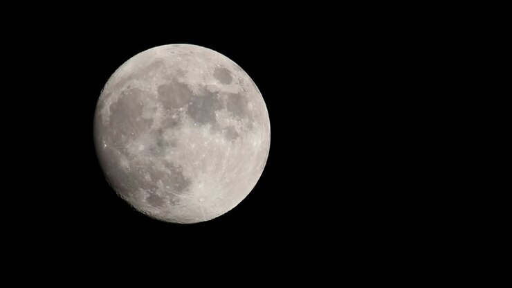 Lua Cheia Brilhante Em Contraste Com Um Céu Preto E Escuro, Movendo-se Do Meio Esquerdo Do Quadro Em Direção Ao Centro Superior Do Quadro