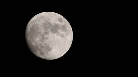 Luna-Llena-Brillante-Contra-El-Cielo-Negro-Oscuro,-Moviéndose-Desde-El-Centro-Izquierdo-Del-Marco-Hacia-El-Centro-Superior-Del-Marco