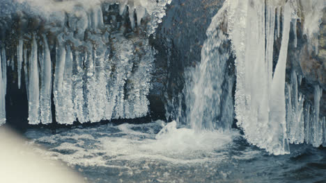 small waterfall of a frozen river in winter, wide shot, slow motion, handheld