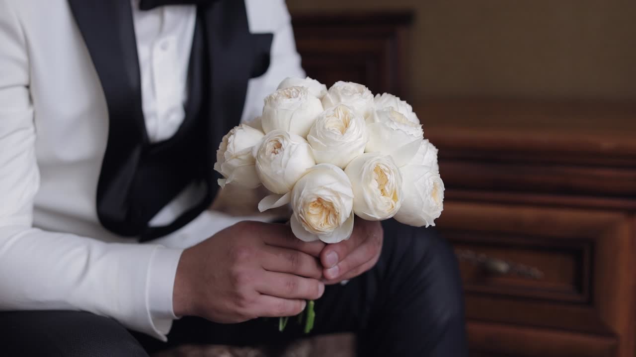 신랑 이 결혼식 꽃줄 을 들고 있다