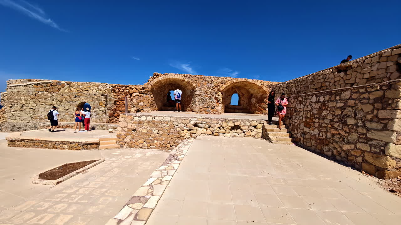 Tourists enjoying views and walking along ancient wall of Firka Venetian Fortress in Chania, Greece