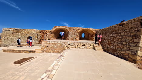 tourists enjoying views and walking along ancient wall of firka venetian fortress in chania, greece