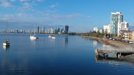 Aerial-view-of-a-beach-side-town-with-a-city-skyline-in-the-distance