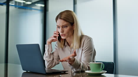 emotional businesswoman calling cellphone at office closeup. angry woman arguing