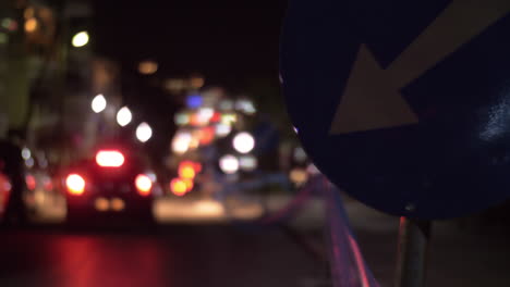 Night-street-with-driving-cars-and-detour-sign