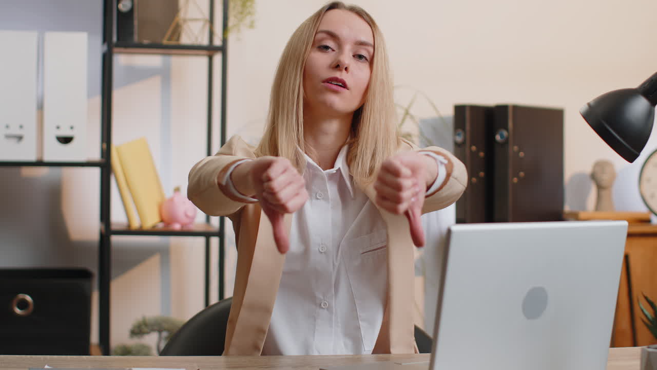 Upset businesswoman show thumbs down dislike bad work disapproval dissatisfied feedback at office