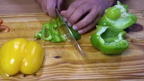rebanar pimientos en juliana sobre tablero de madera cocina dieta sana y saludable
