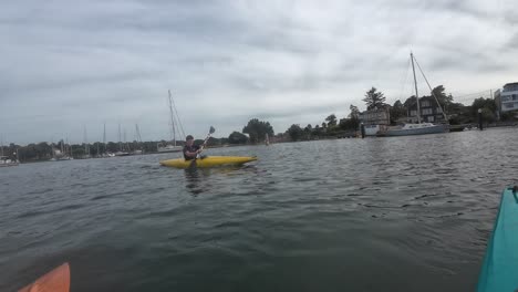 experience an exhilarating kayaking adventure on the scenic river hamble, south coast england. dynamic action, vibrant kayaks, and serene waters under shifting skies provide an invigorating scene