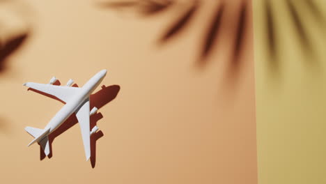 close up of white airplane model and copy space and leaf shadow on yellow background