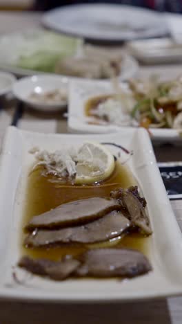 enjoying a dish of sliced meat with chopsticks