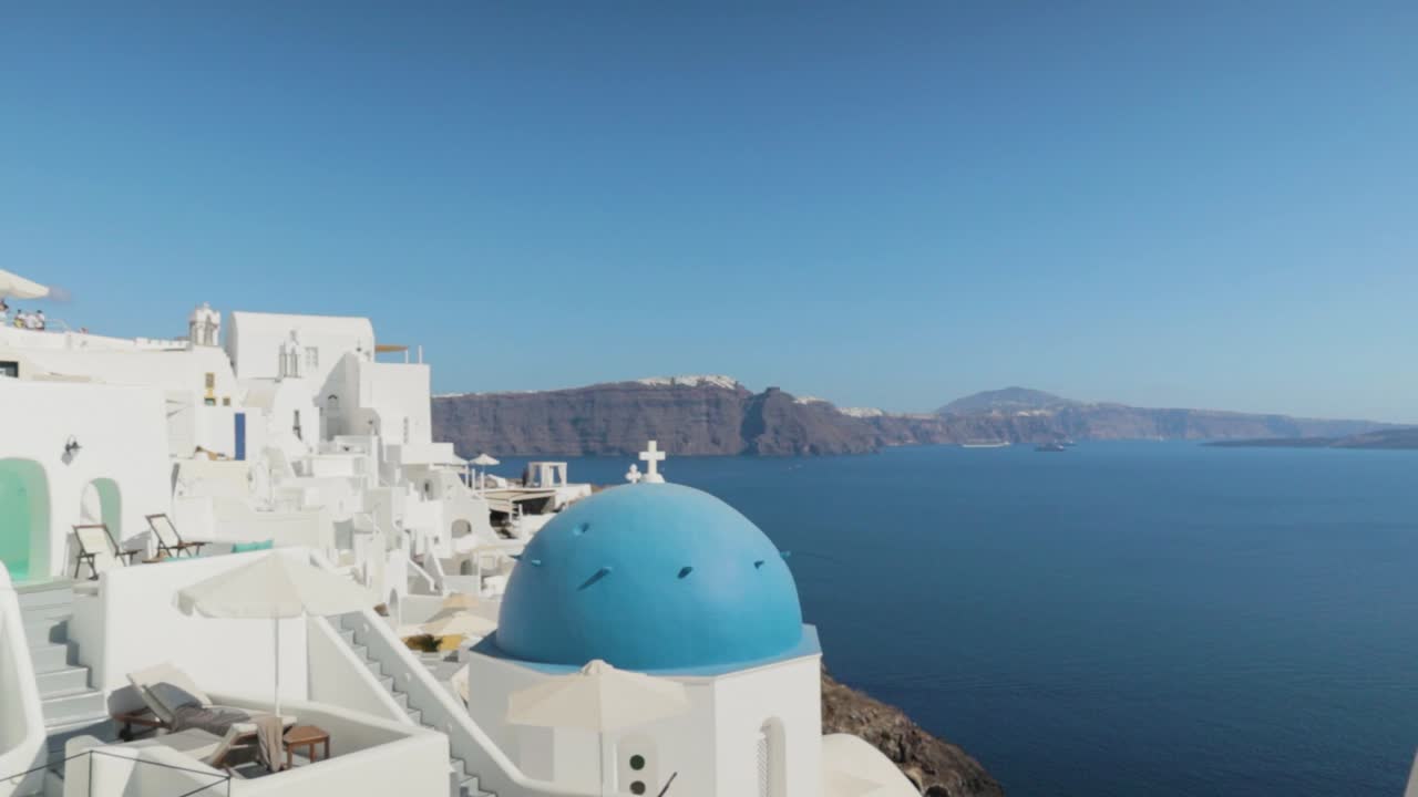 panorámica sobre la iglesia griega azul blanca con vistas al mar en santorini, grecia