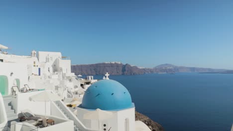 Schwenken-über-Weiß-Blau-Griechische-Kirche-Mit-Meerblick-Auf-Santorini,-Griechenland