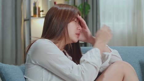 unhappy lonely depressed young asian woman at home, she is sitting on the couch, depression concept