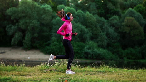 a morning jog in the park near the pond in the sunny rays of dawn, the girl is preparing to mariano and lead a healthy lifestyle