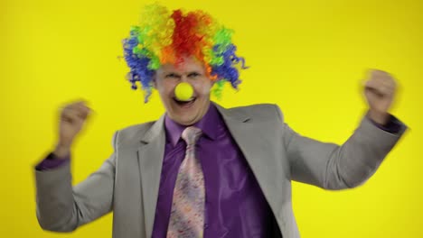 Clown-businessman-entrepreneur-in-wig-dancing,-celebrate,-making-silly-faces