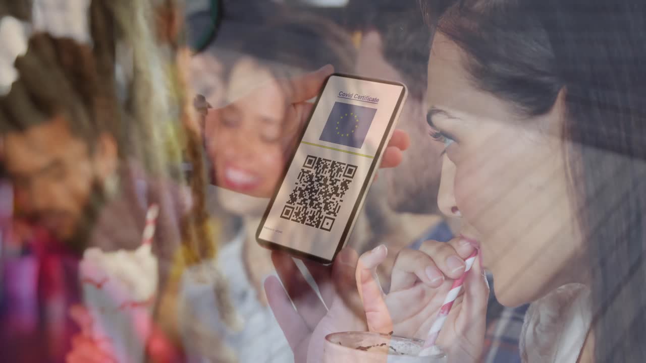 Woman holding a smartphone with qr code on screen against caucasian woman drinking a smoothie