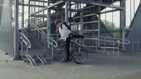 man with bicycle and videographer in urban setting