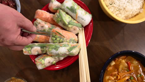 plate of spring rolls with wooden chopsticks on the table with main course dishes